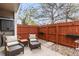 Cozy outdoor patio with seating, a privacy fence, and charming string lights for outdoor relaxation at 7476 E Arkansas Ave # 35-01, Denver, CO 80231