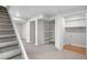 Finished basement area with stairs, neutral paint, shelving and ample space for storage at 10234 W Geddes Cir, Littleton, CO 80127