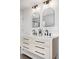 Bright bathroom featuring a double vanity with elegant mirrors and modern fixtures at 10234 W Geddes Cir, Littleton, CO 80127