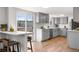 Modern kitchen with an island counter with stools, hardwood floors, and a sliding door to a deck at 10234 W Geddes Cir, Littleton, CO 80127