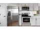 Well-equipped kitchen features stainless steel appliances and white cabinets with gold handles at 10234 W Geddes Cir, Littleton, CO 80127