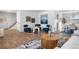 Open-concept living area with hardwood floors, stylish seating, and a view of the dining area at 10234 W Geddes Cir, Littleton, CO 80127
