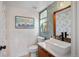 Powder bath featuring a wood vanity with a square vessel sink, unique wallpaper, and a framed Breakerwater print at 3636 Lipan St, Denver, CO 80211