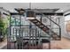 Contemporary dining area featuring a glass table, metal chairs, and a modern staircase with a metal railing at 3636 Lipan St, Denver, CO 80211