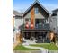 Modern two-story home with a brick facade, balcony, and covered patio featuring an outdoor seating area at 3636 Lipan St, Denver, CO 80211
