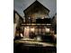Modern two-story home with a brick facade, balcony, and covered patio featuring an outdoor seating area at night at 3636 Lipan St, Denver, CO 80211