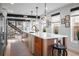 Modern kitchen featuring a large center island, stainless steel appliances, and a view of the staircase at 3636 Lipan St, Denver, CO 80211