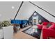 Cozy living area with sloped ceilings, modern decor, and a brightly colored sofa, creating a warm inviting space at 3636 Lipan St, Denver, CO 80211