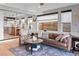 Inviting living room featuring hardwood floors, a leather sofa, and a view into the adjacent modern kitchen at 3636 Lipan St, Denver, CO 80211