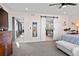 Spacious bedroom with plush carpet, neutral paint, barn door to ensuite, and stylish decor at 3636 Lipan St, Denver, CO 80211