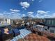 Spacious rooftop deck with stunning city views features outdoor seating, umbrella, and wood flooring at 3636 Lipan St, Denver, CO 80211