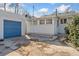 View of the backyard, garage with blue door, and sunroom addition at 1900 S Gilpin St, Denver, CO 80210