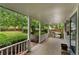 Spacious covered porch featuring classic white columns and railings with a view of the yard at 1900 S Gilpin St, Denver, CO 80210