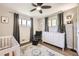 Cozy bedroom featuring a crib, chair, and dresser, with ample natural light, creating a warm atmosphere at 1475 Lucille Ct, Northglenn, CO 80233
