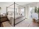 Bright bedroom with a four-poster bed, hardwood floors, and natural light from a sliding glass door at 5880 W 39Th Pl, Wheat Ridge, CO 80212