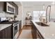 Modern kitchen featuring dark wood cabinets, white countertops, and stainless steel appliances, creating a stylish and functional space at 5880 W 39Th Pl, Wheat Ridge, CO 80212