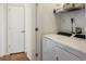 Well-lit laundry area featuring a modern washer and dryer set with convenient overhead shelving for storage solutions at 5880 W 39Th Pl, Wheat Ridge, CO 80212
