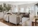 Open-concept living room showcasing a large grey sectional, neutral armchairs, and sliding glass doors for outdoor access at 5880 W 39Th Pl, Wheat Ridge, CO 80212