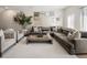 Bright living room featuring a large grey sectional, white rug, stylish decor, and an abundance of natural light at 5880 W 39Th Pl, Wheat Ridge, CO 80212