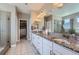 Bathroom with dual sinks, granite countertops, walk-in closet, and glass shower at 5923 S Jamestown Ct, Aurora, CO 80016