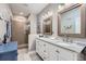 Bright bathroom featuring a double vanity with granite countertop, updated fixtures, and a walk-in shower at 5923 S Jamestown Ct, Aurora, CO 80016