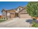Charming two-story home with a stone and siding exterior, driveway, mature tree and multiple garage doors at 5923 S Jamestown Ct, Aurora, CO 80016
