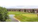 Aerial perspective of a golf course with a pond, surrounded by multi-story residential buildings, tree lines and green space at 2700 W Riverwalk Cir # C, Littleton, CO 80123