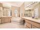 Luxurious bathroom featuring dual vanities, a soaking tub, and a separate glass-enclosed shower at 2700 W Riverwalk Cir # C, Littleton, CO 80123