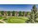Scenic view of a golf course winding through residential buildings, showcasing green fairways and tree-lined streets at 2700 W Riverwalk Cir # C, Littleton, CO 80123