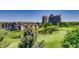 Scenic golf course with a pond, framed by trees, and a modern high rise in the background with residential area at 2700 W Riverwalk Cir # C, Littleton, CO 80123