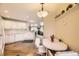 Well-lit kitchen with white cabinetry, modern appliances, and breakfast table with view to living room at 2700 W Riverwalk Cir # C, Littleton, CO 80123