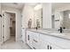 Bathroom featuring double vanity, large mirror, and white cabinetry at 22025 E 45Th Ave, Aurora, CO 80019