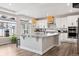 Modern kitchen featuring a large island with seating, stainless appliances, and ample natural light from large windows at 22025 E 45Th Ave, Aurora, CO 80019