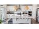 Bright kitchen boasts white cabinets, stainless steel appliances, and an expansive island with pendant lighting at 22025 E 45Th Ave, Aurora, CO 80019