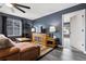 Cozy living room with a leather sofa, dark blue accent wall, and wood-look flooring at 22025 E 45Th Ave, Aurora, CO 80019