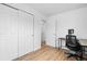 Bright bedroom features hardwood floors, a modern desk, and a double-door closet at 8190 Raleigh Pl, Westminster, CO 80031