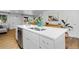 Modern kitchen island featuring white cabinetry, a stainless steel dishwasher, and ample counter space at 8190 Raleigh Pl, Westminster, CO 80031