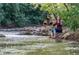 Picturesque creek with a barefoot Personal sitting on rocks and two people walking in the background at 2010 Pearl St # B, Boulder, CO 80302