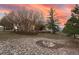 Spacious backyard with a fire pit, mature trees, and a natural landscape at 265 Ox Yoke Way, Monument, CO 80132