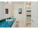 Well-lit bathroom with patterned wallpaper, walk-in shower, and teal countertop at 265 Ox Yoke Way, Monument, CO 80132