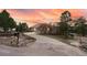Long driveway leading to an attached garage, surrounded by trees and landscaping at 265 Ox Yoke Way, Monument, CO 80132