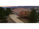 Three-car garage with large driveway, mature trees, and attractive home exterior at 265 Ox Yoke Way, Monument, CO 80132
