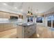Open kitchen with stone island, stainless appliances, and scenic views from large windows at 265 Ox Yoke Way, Monument, CO 80132