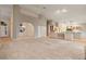 Open living area with vaulted ceilings, neutral carpet, and a view into the dining room and kitchen at 265 Ox Yoke Way, Monument, CO 80132