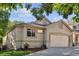 Charming home featuring an attached garage, well-kept lawn, and neutral stucco at 5095 S Newcombe Ct, Littleton, CO 80127