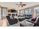 Comfortable living room showcasing a cozy fireplace, large windows, and plush leather furniture at 11020 E 150Th Pl, Brighton, CO 80602