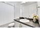 Bathroom with white cabinets, dark countertop, and shower-tub combo at 4407 N Quemoy St, Aurora, CO 80019