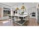 Bright kitchen featuring a large island, stainless steel appliances, modern pendant lighting, and hardwood floors at 4407 N Quemoy St, Aurora, CO 80019