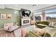 Cozy living room featuring a fireplace, hardwood floors, large windows, and comfortable seating at 4407 N Quemoy St, Aurora, CO 80019