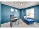 Well-lit home office featuring blue walls, a modern desk, and a lounge chair at 4407 N Quemoy St, Aurora, CO 80019